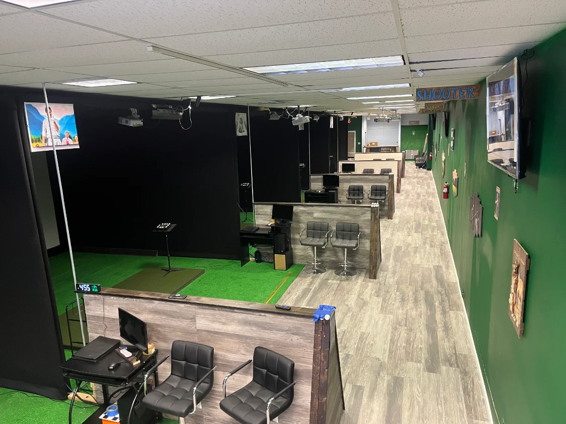 Row of simulator bays with seating at Tee-ed Off
