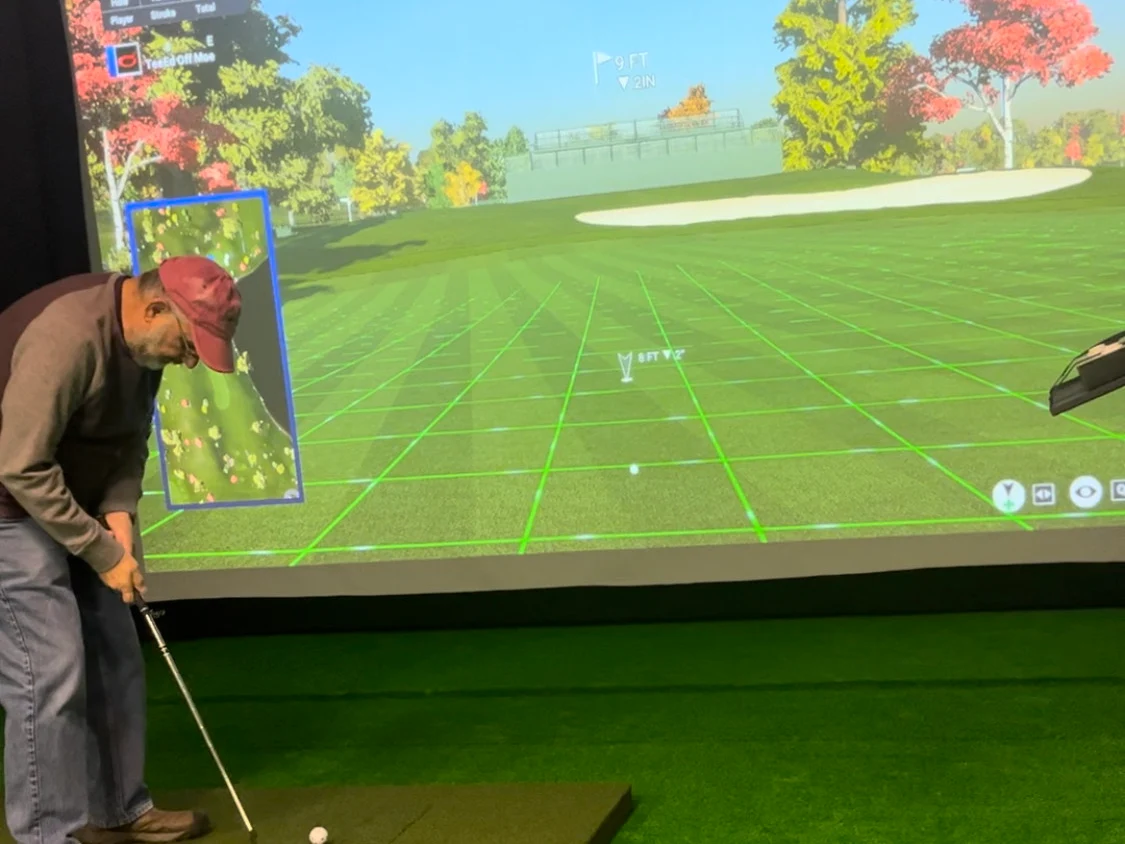 Golfer putting toward a simulator screen